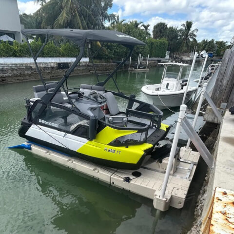 A jet ski is docked on a dock next to a boat.